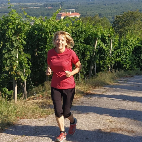Rita joggt einen Weg im Hopfenanbaugebiet hinauf.